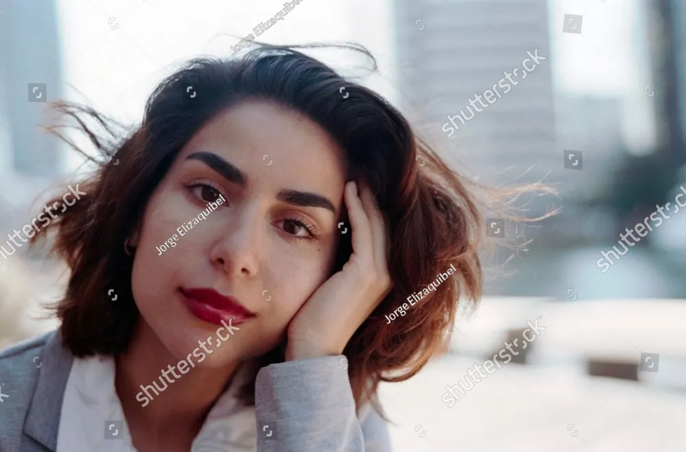 A young woman resting her head in her hand