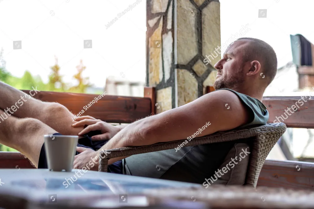 A man relaxing in a chair on a sunny porch