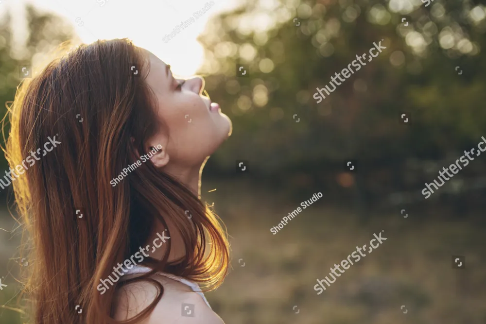 A young woman with her eyes closed in the evening sun